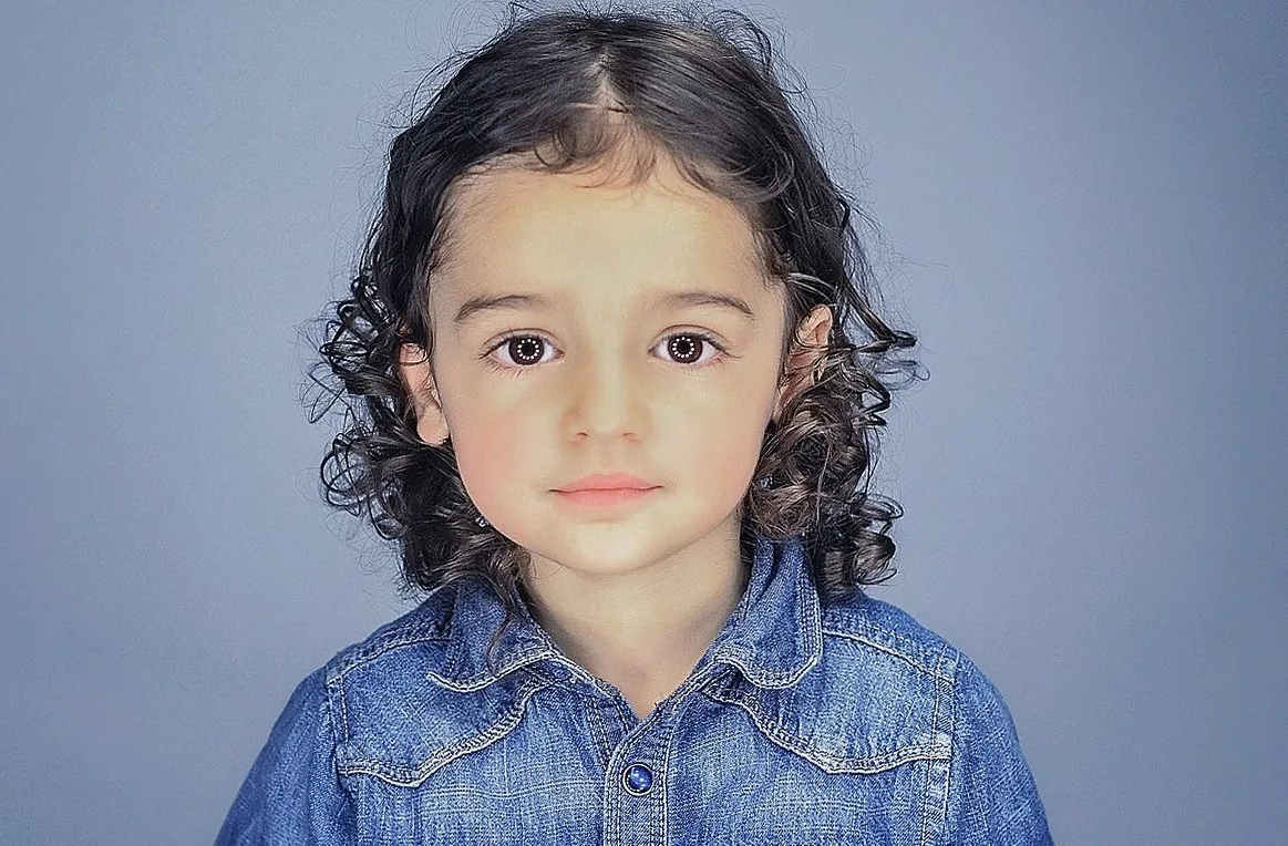 デニムシャツを着た巻き髪の女の子のポートレート